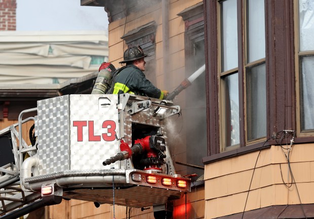Firefighters work to overhaul a fatal six alarm fire on Meridian Street in East Boston. (Matt Stone/Boston Herald)
