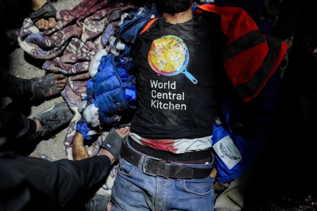 The body of a person wearing a World Central Kitchen t-shirt lies on the ground at the Al Aqsa hospital in Deir al-Balah, Gaza Strip, Monday, April 1, 2024. World Central Kitchen, an aid group, says an Israeli strike that hit its workers in Gaza killed at least seven people, including several foreigners. (AP Photo/Abdel Kareem Hana)