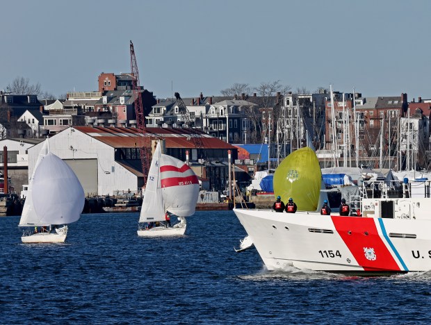 The Coast Guard Cutter William Sparling plies the waters of Boston Harbor past sailors flying spinnakers as they frostbite on Feb. 3. (Staff Photo By Stuart Cahill/Boston Herald)