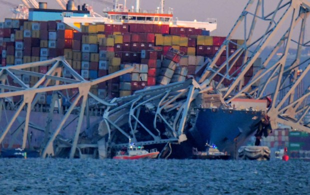 Emergency boats float around a container ship whose bow received damage after the Francis Scott Key Bridge crumbled onto the vessel and into the Patapsco River following a collision with the structure overnight. (Karl Merton Ferron/Staff)