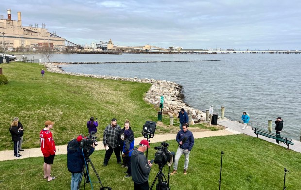 Residents and media gather to view the collapsed Key Bridge from Stoney Beach, a private community south of the Brandon Shores power plant, at left. (Amy Davis/Staff)