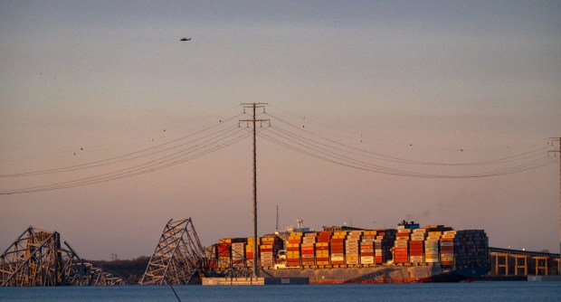 The Maersk container ship Dali and the remains of the collapsed Francis Scott Key Bridge are seen at sunrise Tuesday. The massive container ship was adrift early Tuesday as it headed toward the iconic Francis Scott Key Bridge, losing power before colliding with one of the bridge's support columns. (Jerry Jackson/Staff)